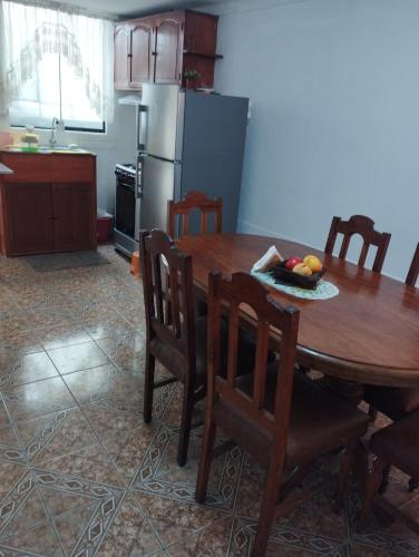 伊洛Departamento Amoblado en Urba. Ilo的厨房配有带椅子的木桌和桌子。