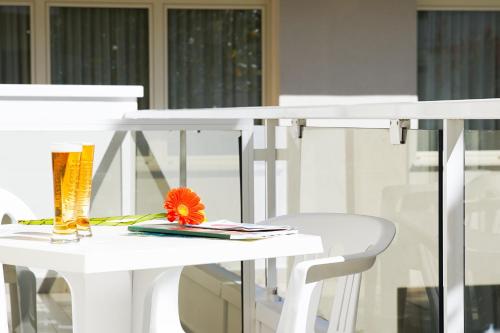 里米尼Hotel Mon Pays的白色的桌子和椅子,上面有花
