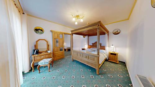StrážaHotel Diana的一间卧室配有天蓬床和镜子