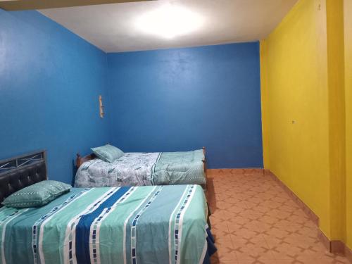 阿亚库乔Casa Huamanga的一间卧室设有两张床和蓝色的墙壁