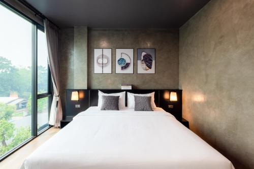 清道The View Chiang Dao Hotel的一间卧室设有一张大床和一个大窗户