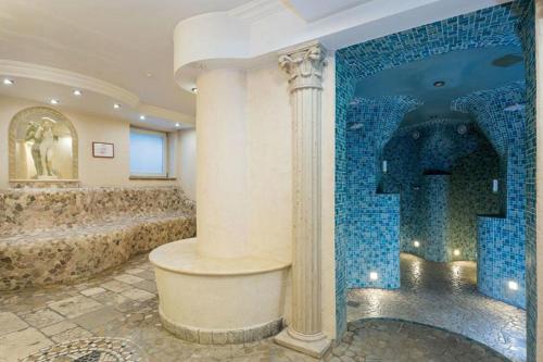 贝里斯泽尔Alpenhof的带淋浴的浴室和蓝色瓷砖墙
