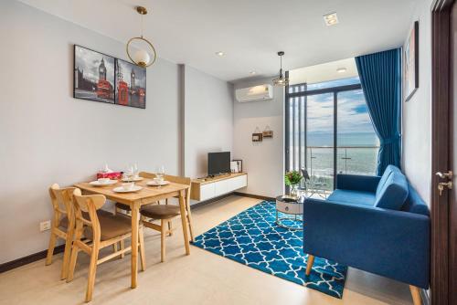 头顿CSJ Seaside - Căn Hộ Cạnh Biển的客厅配有桌子和蓝色沙发