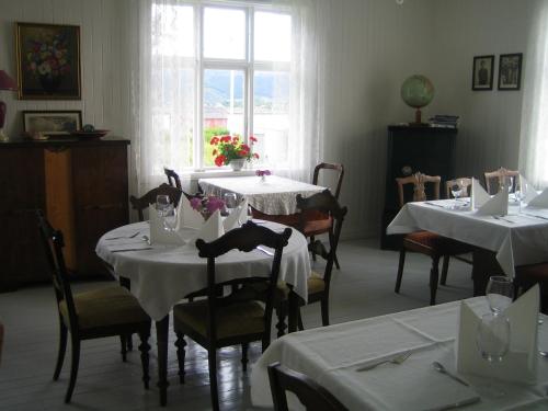 Bø i VesterålenSkagakaia的一间设有白色桌椅和窗户的用餐室