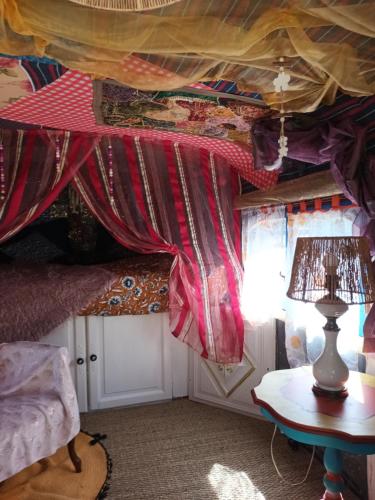 GroléjacGit'an Périgord la Bonne aventure的一间设有窗帘和台灯的桌子的房间