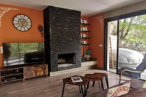 费里切托Maison avec jacuzzi au cœur des montagnes的客厅设有壁炉和电视。