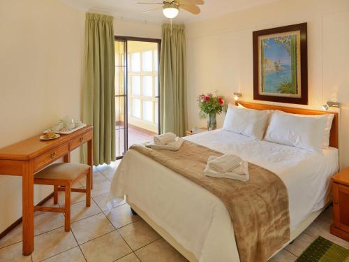 马盖特First Group Costa Smeralda的一间卧室配有一张大床、一张桌子和一张床