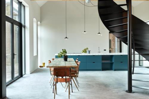 LioessensSuvelfabryk的厨房配有蓝色橱柜和木桌