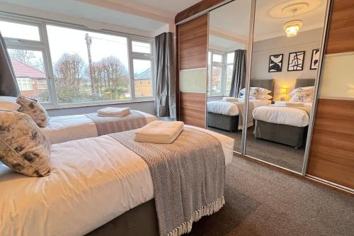 MoortownChelwood Residence的一间卧室设有两张床和大镜子