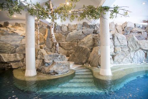 锡利安蔚兰布伦恩酒店的一座带岩石墙的度假村内的游泳池