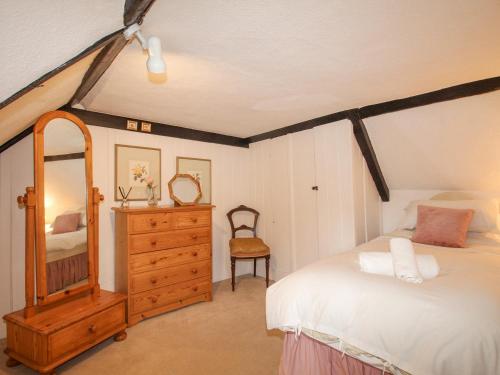 斯塔德兰Vine Cottage的一间卧室配有一张床、梳妆台和镜子