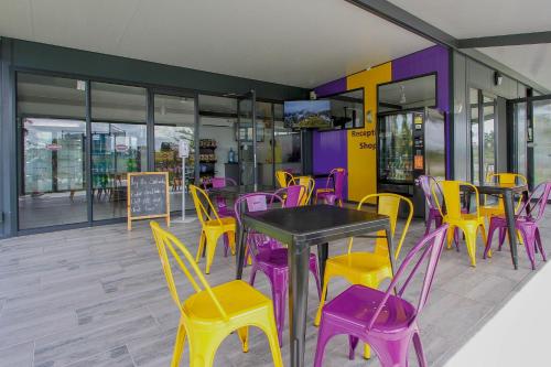 AcornhoekSleepOver Orpen Gate的餐厅设有紫色和黄色的桌椅