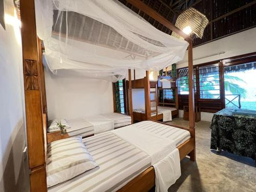 PanganiLui Ushongo Beach House的一间卧室,配有两张床