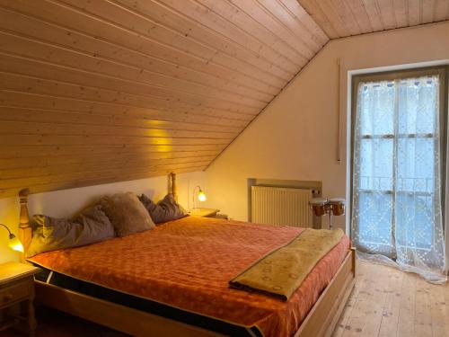 MaierhofFerienhaus Brühler的一间卧室设有一张带木制天花板的大床