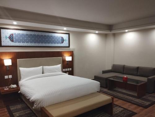 吉尔吉特Avari Xpress Gilgit的酒店客房,配有床和沙发