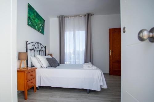 科尼尔-德拉弗龙特拉Habitación Aponiente的卧室配有白色的床和窗户。