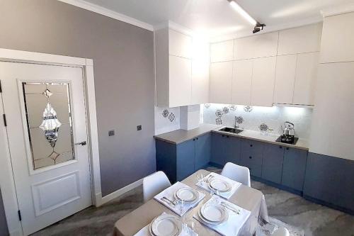 TürkistanАпартамент keruen saray的一间带桌椅的厨房和一间带蓝色橱柜的厨房