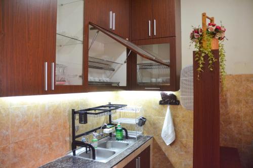日惹茹玛康婷家庭旅馆的一个带水槽和木橱柜的厨房