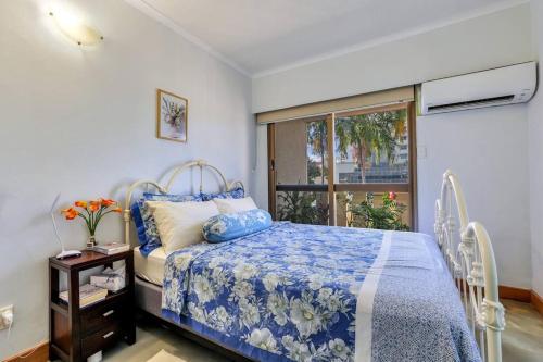 达尔文Joyful Esplanade City Stay的一间卧室配有一张带蓝色棉被的床和窗户。