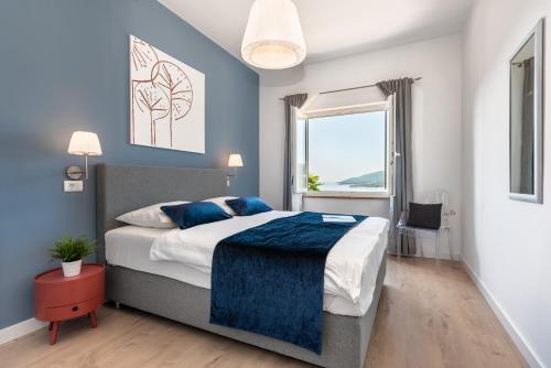 拉巴克Apartment Zulijani House Helis B7的一间卧室配有一张蓝色墙壁的床和一扇窗户