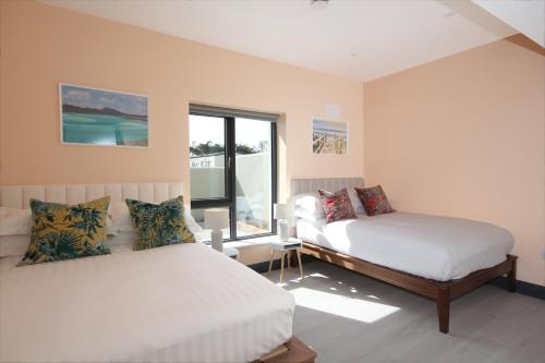 罗斯莱尔Burrow Park Holiday Apartments的一间卧室设有两张床和窗户。