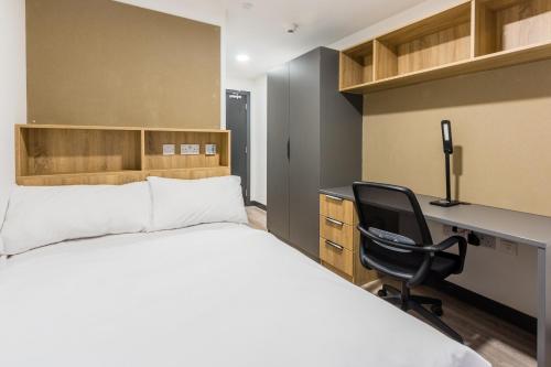 都柏林Destiny Student - Ardee Point的一间卧室配有一张床、一张桌子和一把椅子