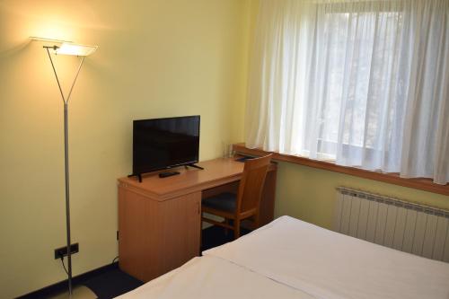 萨格勒布图梅斯拉夫大教堂酒店的酒店客房配有一张书桌、一台电视和一张床