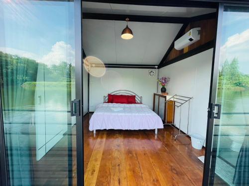 北碧เรือนแพคุณมน-Khun Mon Raft的一间卧室设有床和滑动玻璃门