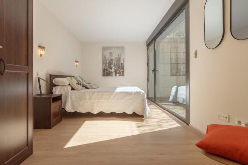 略迪奥Beautiful house 15 min away from Bilbao的一间卧室设有一张床和一个滑动玻璃门