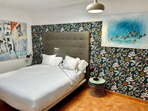 索列尔港Sol Port Soller的一间卧室配有一张带花卉图案墙壁的床