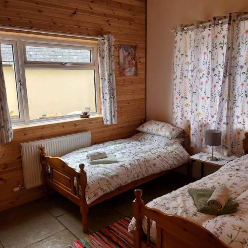 瓦伊河畔海伊Spacious self catering accommodation near HayOnWye的一间卧室设有两张单人床和一个窗户。