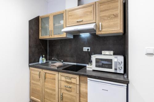 瓦尔纳E-home Apartments的一间带木制橱柜和微波炉的厨房