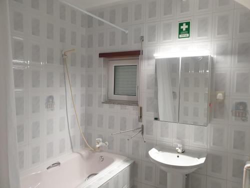 维拉·雷阿尔Cantinho dos Montes的一间带水槽、浴缸和镜子的浴室