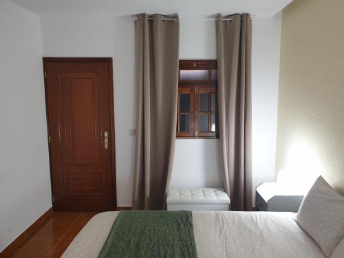 维拉·雷阿尔Cantinho dos Montes的一间卧室设有一张床、一扇门和一扇窗户