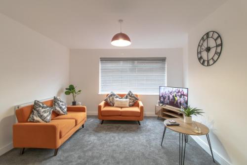 比林汉姆Skipton Lodge的客厅配有2张橙色沙发和电视