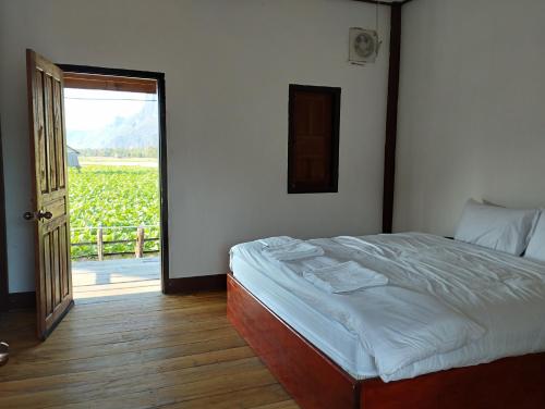 Ban OKonglor Khamchalern Guesthouse and Restaurant的卧室配有一张床,享有葡萄园的景色