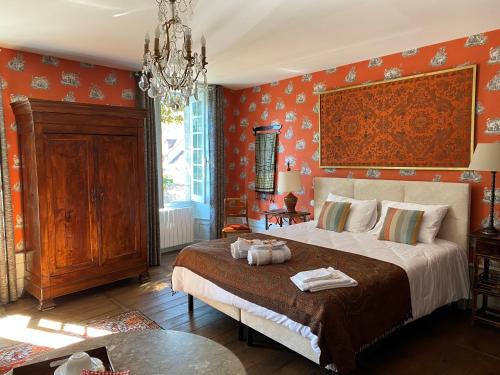 多尔多尼河畔博利厄Le Clos Rodolphe的一间卧室配有一张带橙色墙壁的大床