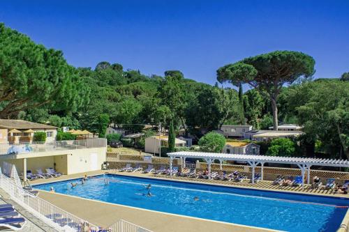加桑Bungalow luxe 3 chambres surplombant le Golf de St Tropez的一个带躺椅和树木的大型游泳池
