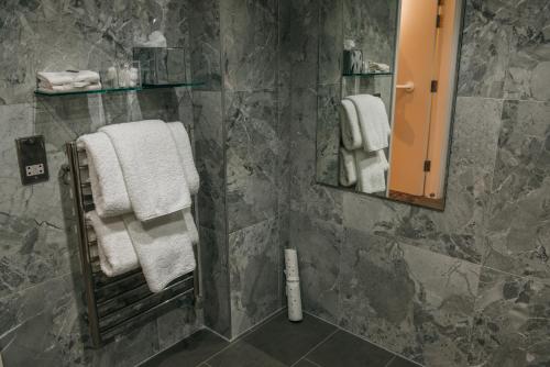 约克The Dean Court的浴室设有灰色大理石墙壁和白色毛巾。