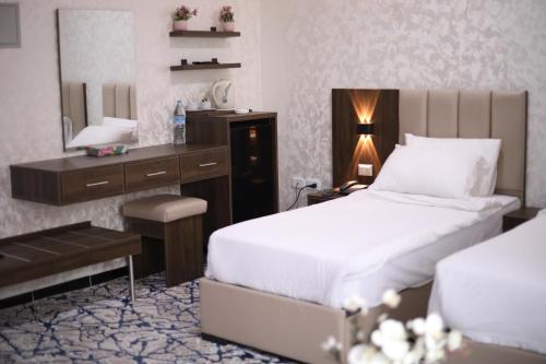 安曼The Castle Hotel的一间卧室配有一张床、一张书桌和一面镜子