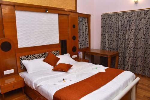 乌提Glen Premium Villa By LexStays的一间卧室配有一张大床和木制床头板