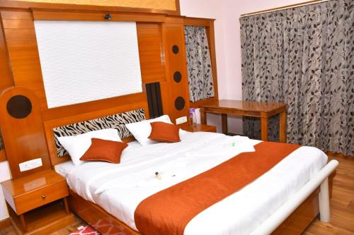 乌提Glen Premium Villa By LexStays的一间卧室配有一张带木制床头板的床和窗户。