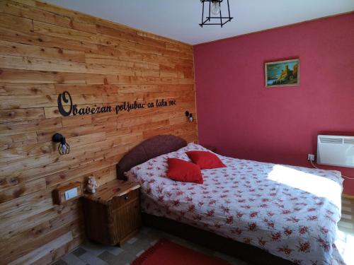 弗尔尼亚奇卡矿泉镇Kuća za odmor Vilin vrt Vrnjacka Banja Otroci的一间卧室设有一张床和木墙