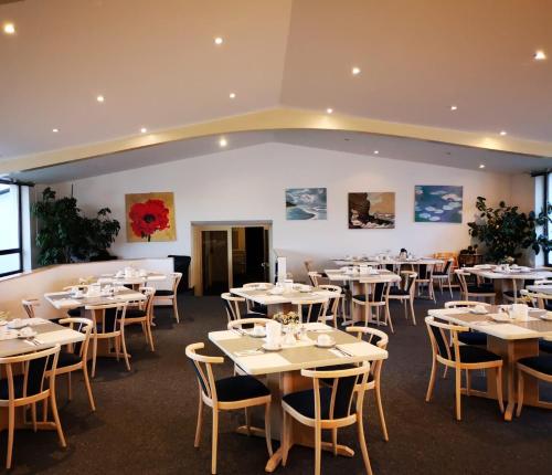 新乌尔姆索耐科勒酒店的一间设有白色桌椅的用餐室