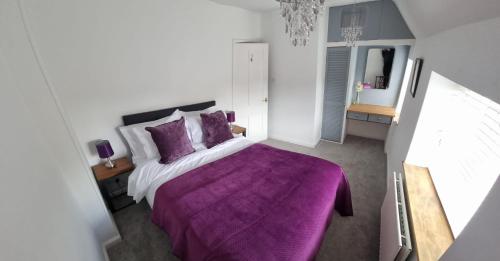 伍德斯托克Yew Tree House的一间卧室配有紫色床和紫色毯子