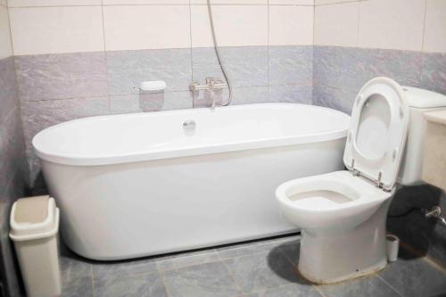 KaragariKingfisher Resort-Muhazi的浴室配有白色浴缸和卫生间。
