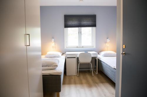 奥萨奥尔萨格隆利特旅舍的小房间设有两张床和一张书桌