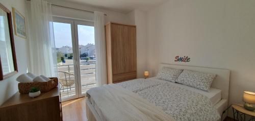 克尔克Apartmani Pavlović的一间卧室设有一张床和一个大窗户