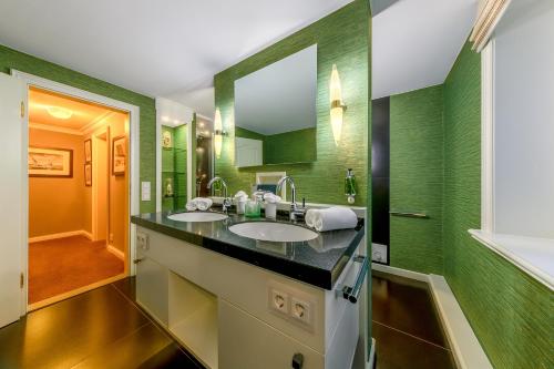 坎彭Hotel Village的一间带两个盥洗盆和大镜子的浴室