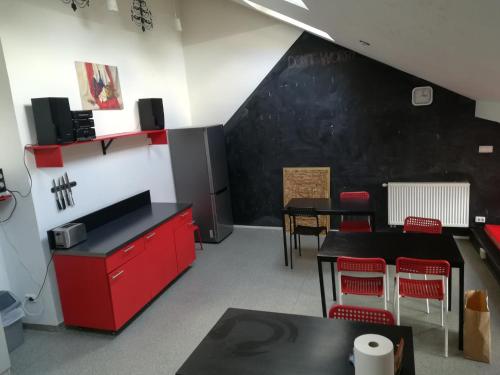 维尔纽斯25 Hours Hostel的一间设有红色橱柜和黑色墙壁的用餐室